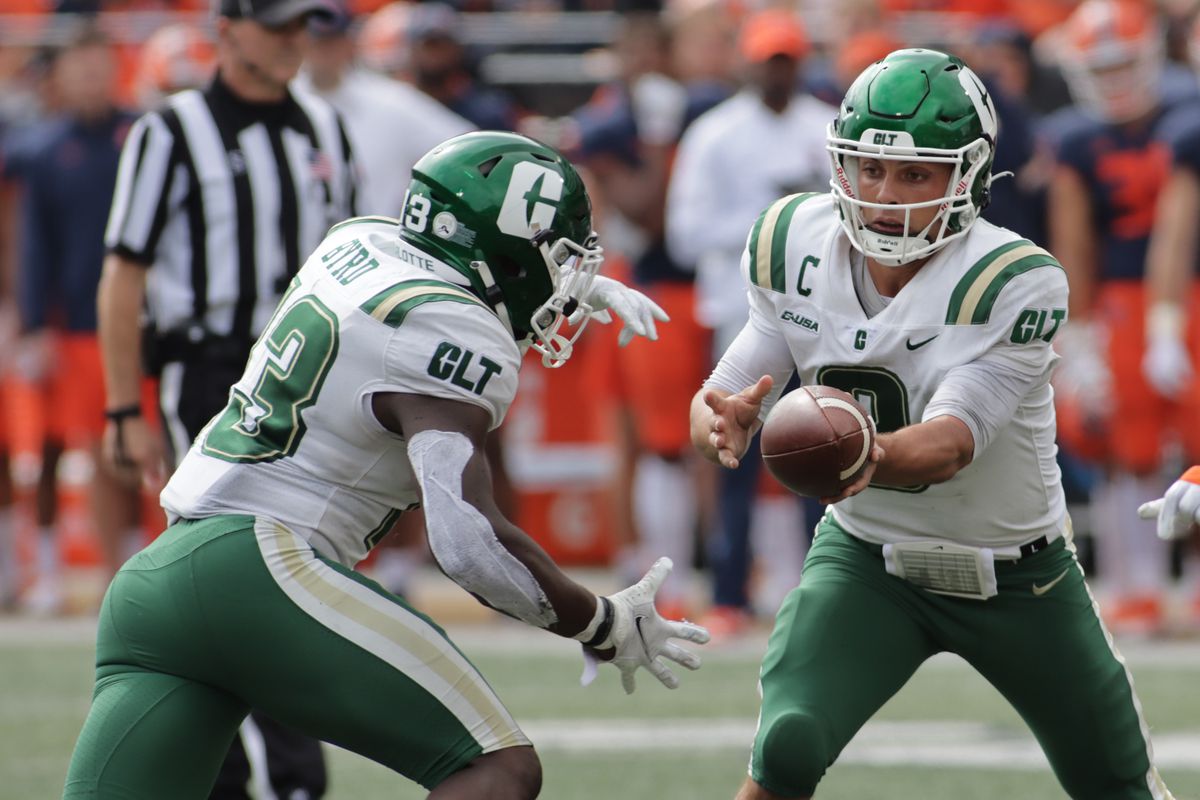 Charlotte 49ers quarterback Chris Reynolds (3) hands the ball off to running back Shadrick Byrd (13) in the second half against the Illinois Fighting Illini at Memorial Stadium.