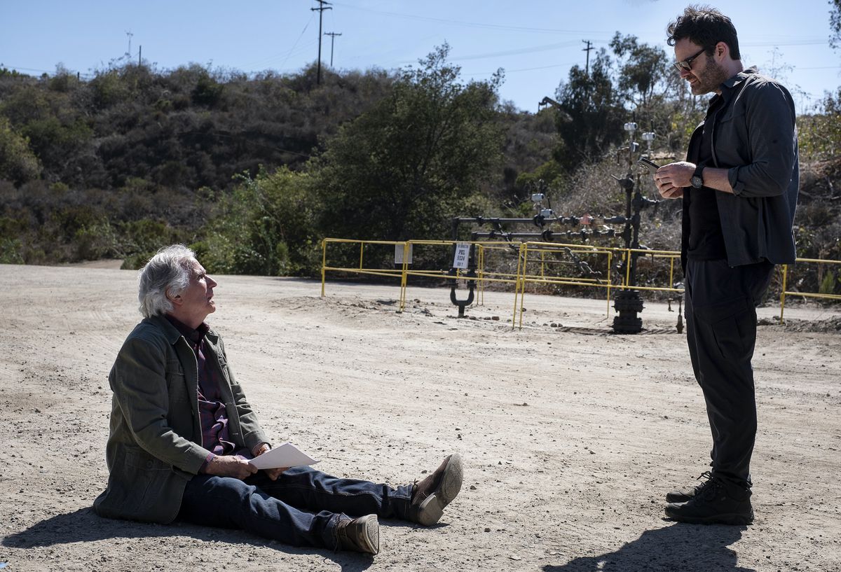Barry talks to Gene, who’s sitting on the ground holding a script and looking up exasperated at Barry