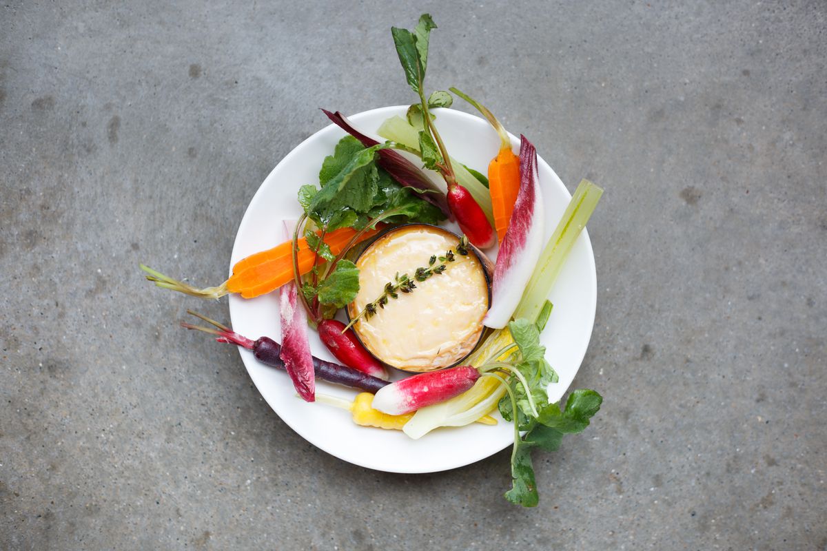 A plate of raw vegetables with a dipping cheese in the centre.