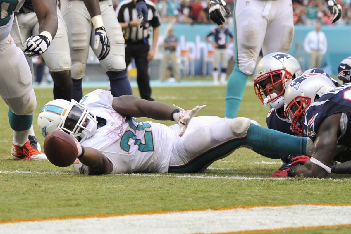  Miami Dolphins running back Knowshon Moreno (28) extends the ball across the goal line for a touchdown against the New England Patriots in the second half at Sun Life Stadium. Miami won 33-20.