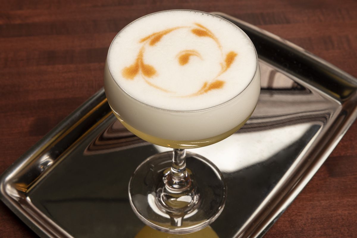 A cocktail with white foam on top.