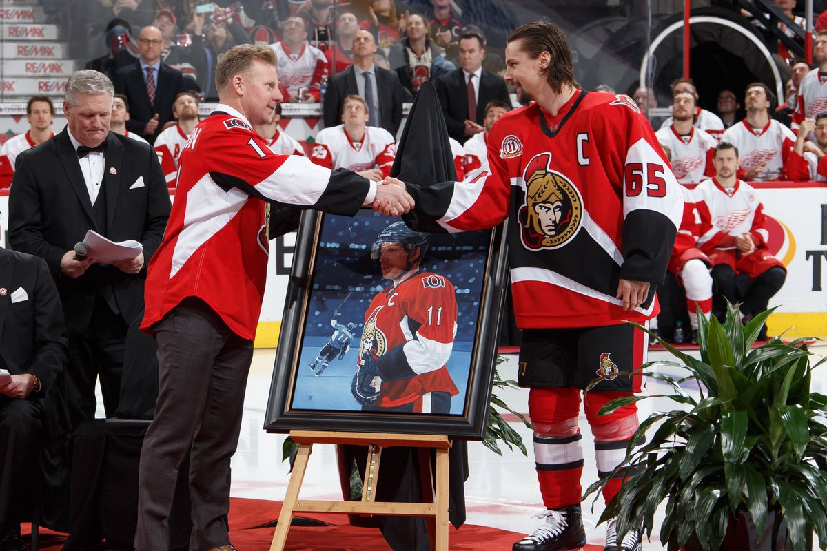 Daniel Alfredsson is presented with a painting by Erik Karlsson #65 of the Ottawa Senators during his jersey retirement ceremony prior to a game against the Detroit Red Wings at Canadian Tire Centre on December 29, 2016 in Ottawa, Ontario, Canada.