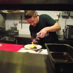In Royale's kitchen, host Chef Richard Blais blowtorches his burger.