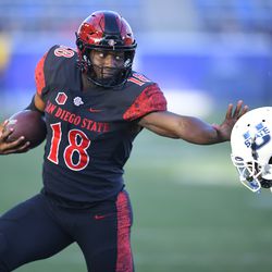 San Diego State quarterback Jalen Mayden (18) straight-arms Utah State safety Hunter Reynolds (27) during an NCAA college football game for the Mountain West Conference Championship, Saturday, Dec. 4, 2021, in Carson, Calif. 