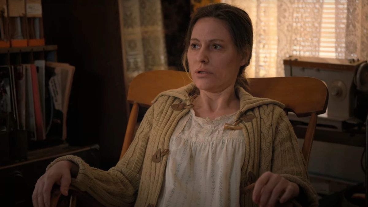 Eleven’s mother Terry Ives (played by Aimee Mullins) sits in a rocking chair looking exhausted and staring out into space.