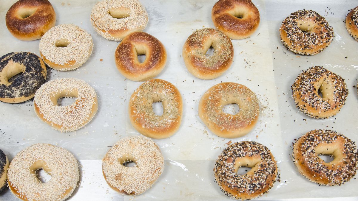 Overhead view of a dozen or so bagels, including everything, poppy, sesame, and more