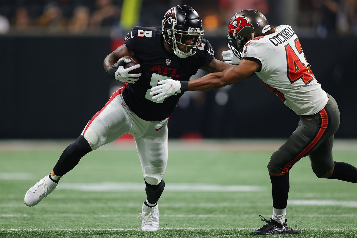 Kyle Pitts #8 of the Atlanta Falcons carries the ball after a reception as Ross Cockrell #43 of the Tampa Bay Buccaneers defends during the second quarter at Mercedes-Benz Stadium on December 05, 2021 in Atlanta, Georgia.
