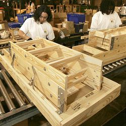 In this photo taken Dec. 21, 2009, workers assemble wooden folding ladders at the Century Industries Folding Attic Stairways plant in Little Rock, Ark.