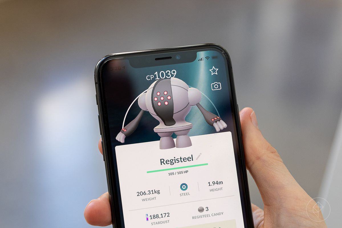 A hand holds up a phone with a Registeel’s Pokémon Go summary on it.
