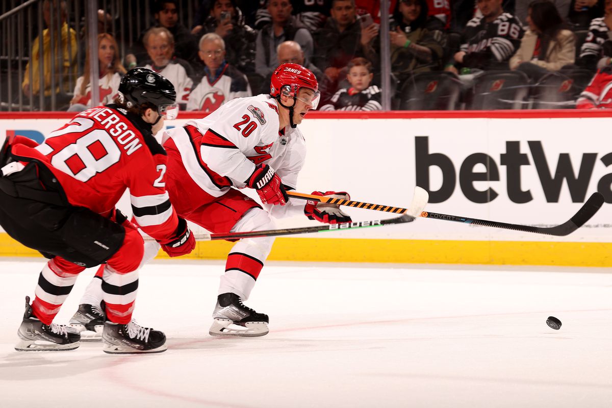 Sebastian Aho #20 of the Carolina Hurricanes and Damon Severson #28 of the New Jersey Devils fight for the puck during the first period at Prudential Center on March 12, 2023 in Newark, New Jersey.