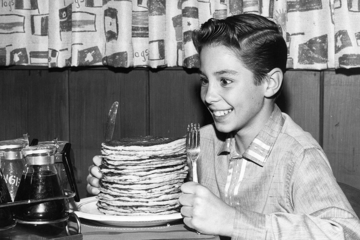 In this file photo, circa 1960, child actor Johnny Crawford looks forward to eating a pile of pancakes in an International House of Pancakes, a chain of eateries in the US started in 1958 by Californian brothers Al and Jerome Lapin. 