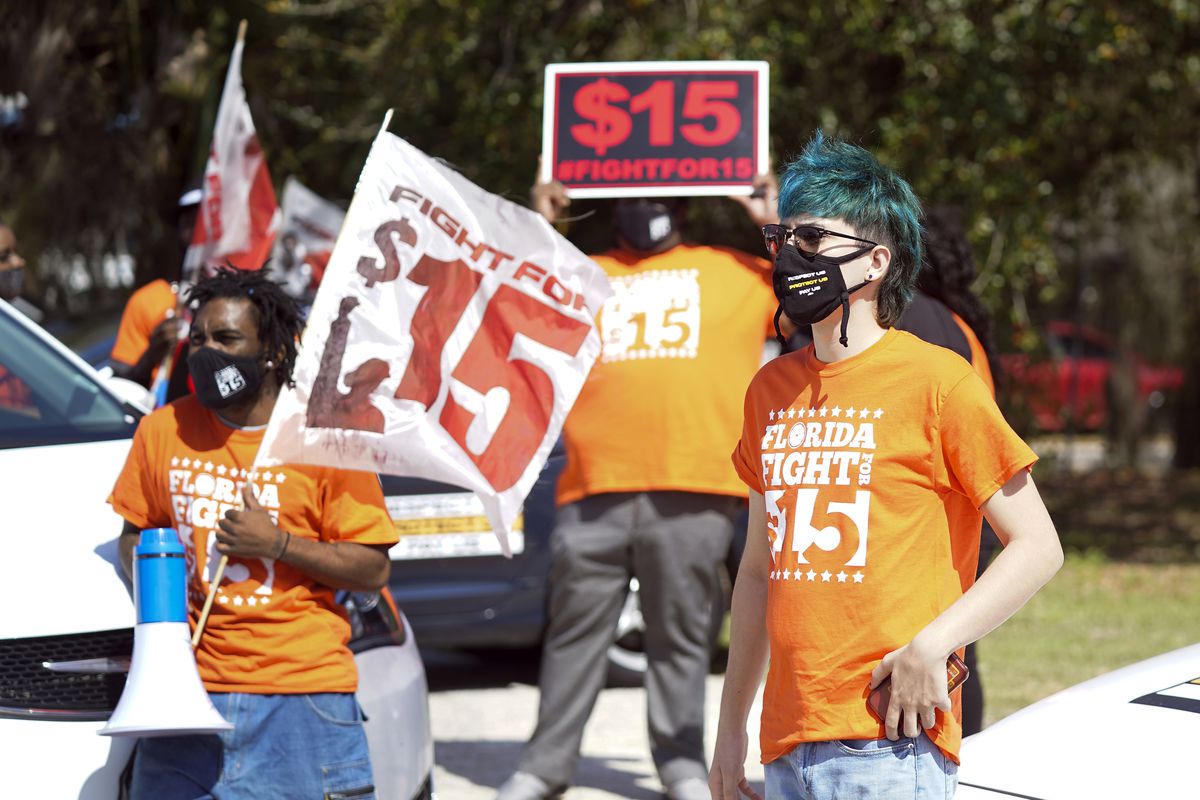 Cristian Cardona, right, an employee at a McDonald’s, attends a rally for a $15 an hour minimum wage Tuesday, Feb. 16, 2021, in Orlando, Fla. 