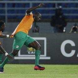 Ivory Coast's captain Yaya Toure, right, is pulled back by teammate Serge Aurier, left, as he celebrates his goal during their African Cup of Nations semifinal soccer match against Congo in Bata, Equatorial Guinea, Wednesday, Feb. 4, 2015. 