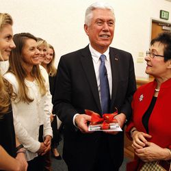 President Dieter F. Uchtdorf, second counselor in the First Presidency of The Church of Jesus Christ of Latter-day Saints, receives a gift from choir members at a fireside for the Salt Lake Inner City Mission in Salt Lake City, Friday, Dec. 4, 2015.