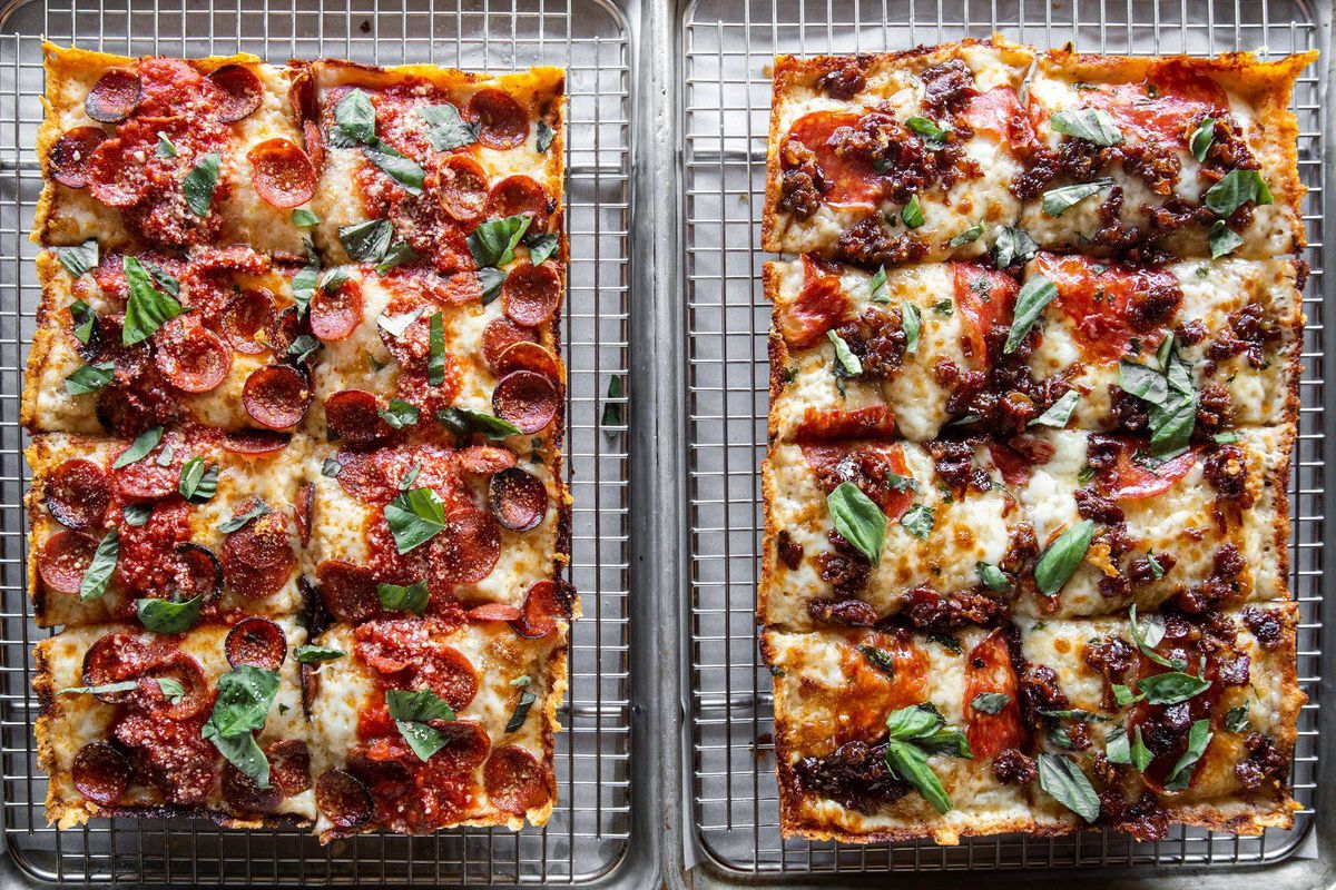 Two Detroit-style pizzas cooling on wire racks side by side