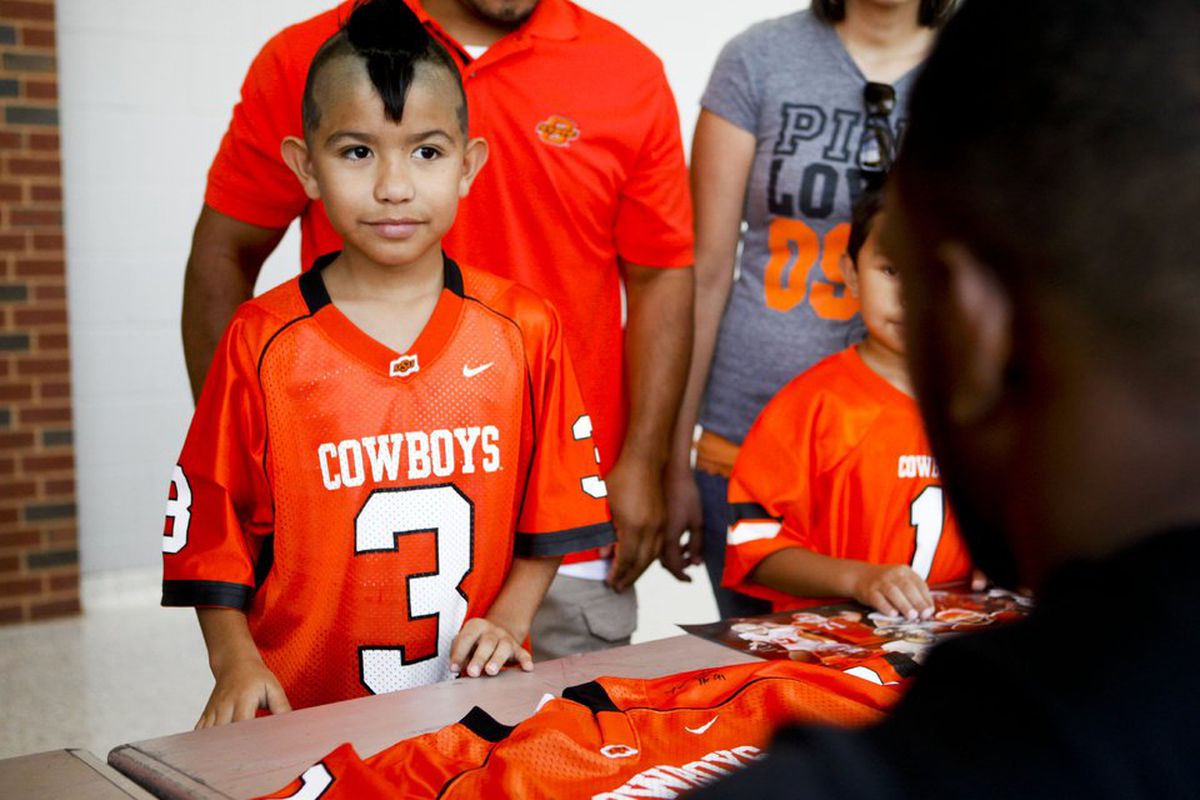 A young Oklahoma State fan, Dominik Villanueva, getting a jersey signed during Fan Appreciation Day last season.
