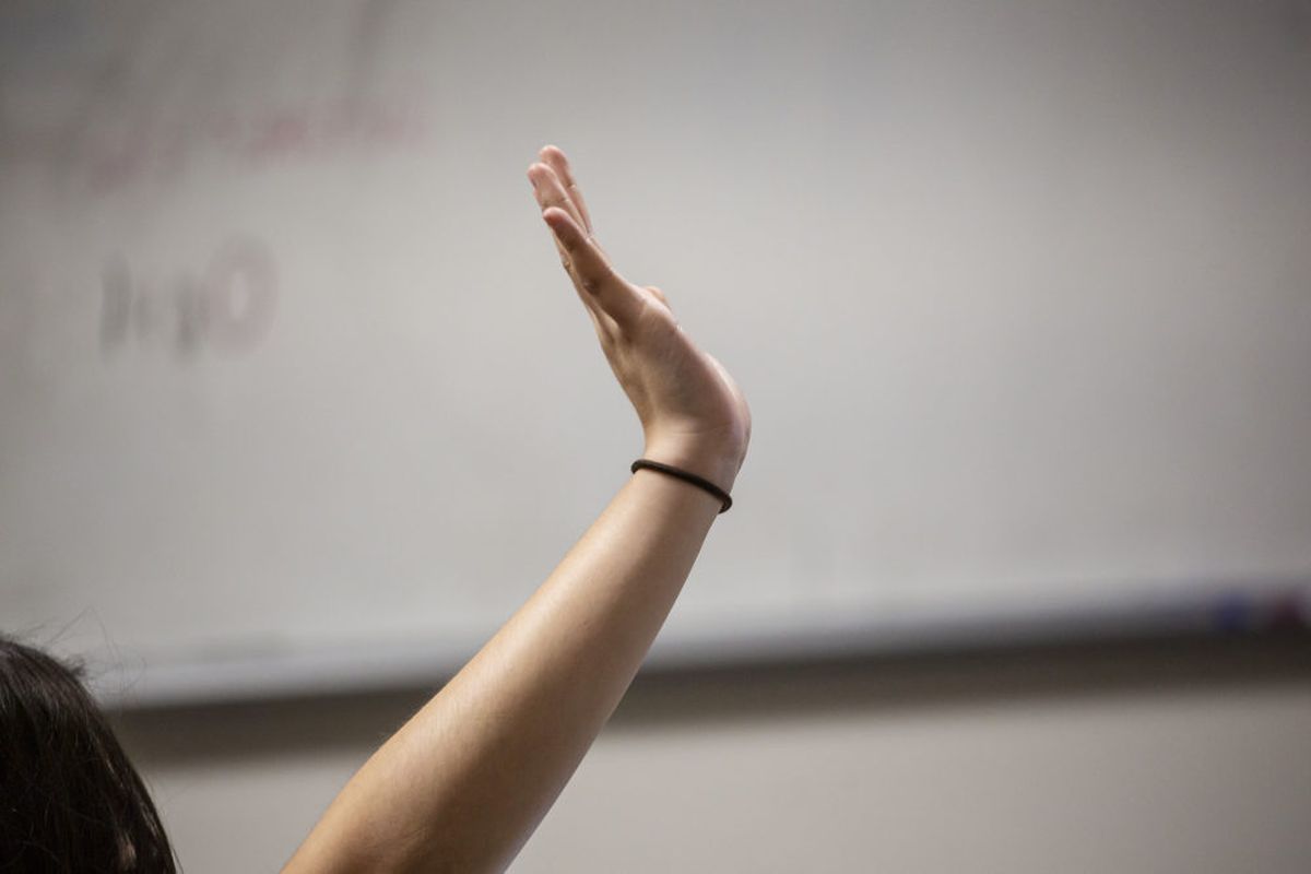 A student raises her hand.