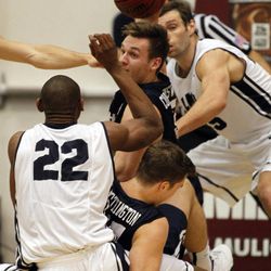 BYU guard Kyle Collinsworth, center, lifts the ball out of a scrum with teammate Luke Worthington and Loyola Marymount forward Godwin Okonji (22) and guard David Humphries, right, during the second half of an NCAA college basketball game in Los Angeles, Saturday, Feb. 7, 2015. BYU won 87-68.