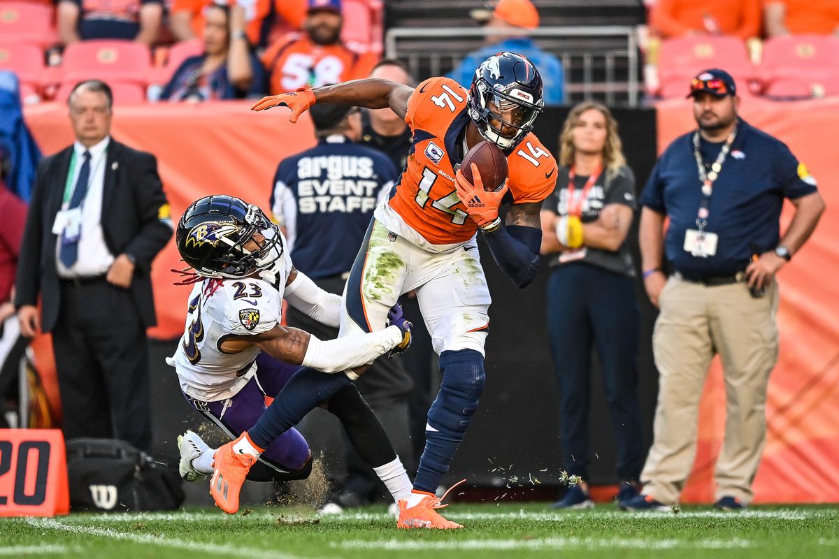 Courtland Sutton #14 of the Denver Broncos is tackled by Anthony Averett #23 of the Baltimore Ravens after a fourth quarter catch in a game at Empower Field at Mile High on October 3, 2021 in Denver, Colorado.
