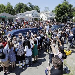 The hearse carrying the body of Muhammad Ali passes in front of his boyhood home during his funeral procession Friday, June 10, 2016, in Louisville, Ky. Ali's home is the second house from the left. 