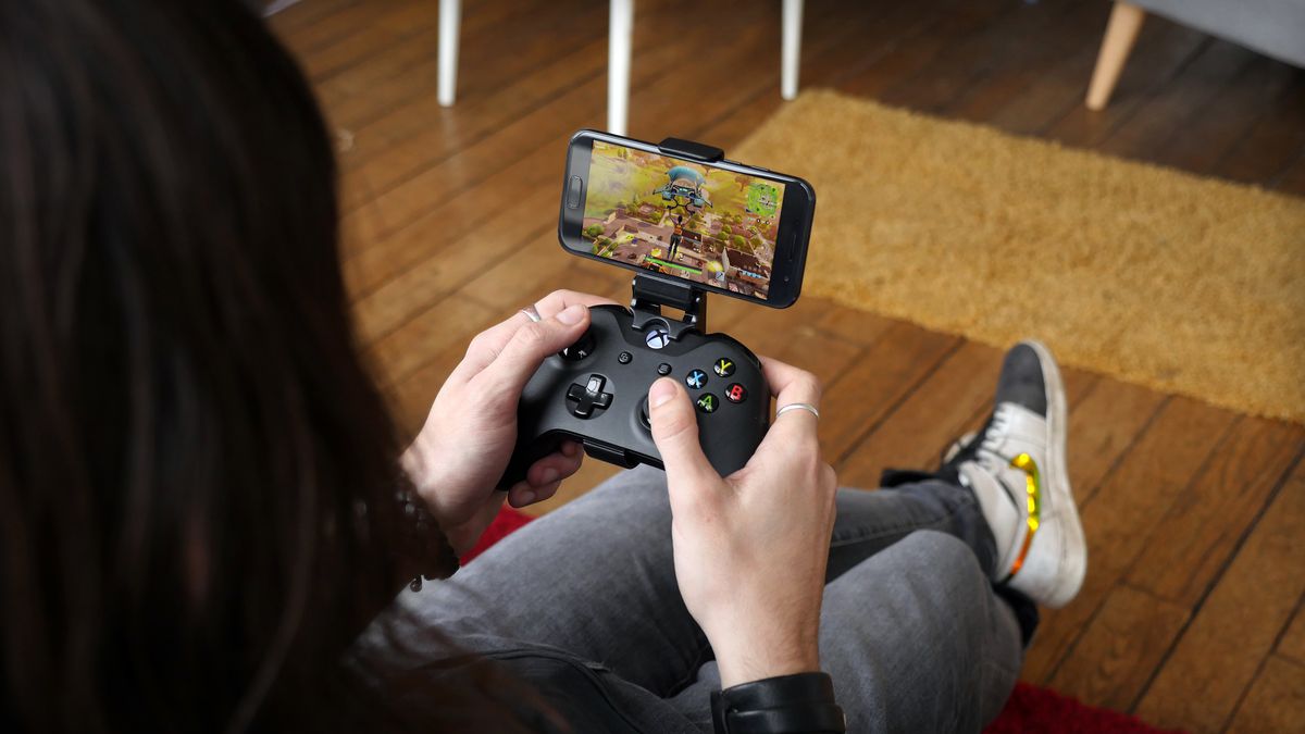 a person playing Fortnite on an Android phone with an Xbox One controller via Shadow