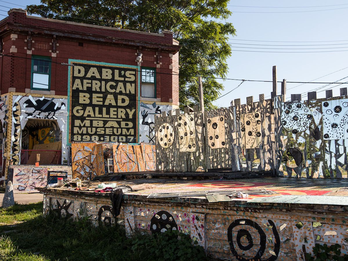 The exterior of the African Bead Museum. There is art painted on the walls and pathway. There is a sign on the museum that reads: Dabl’s African Bead Gallery. 