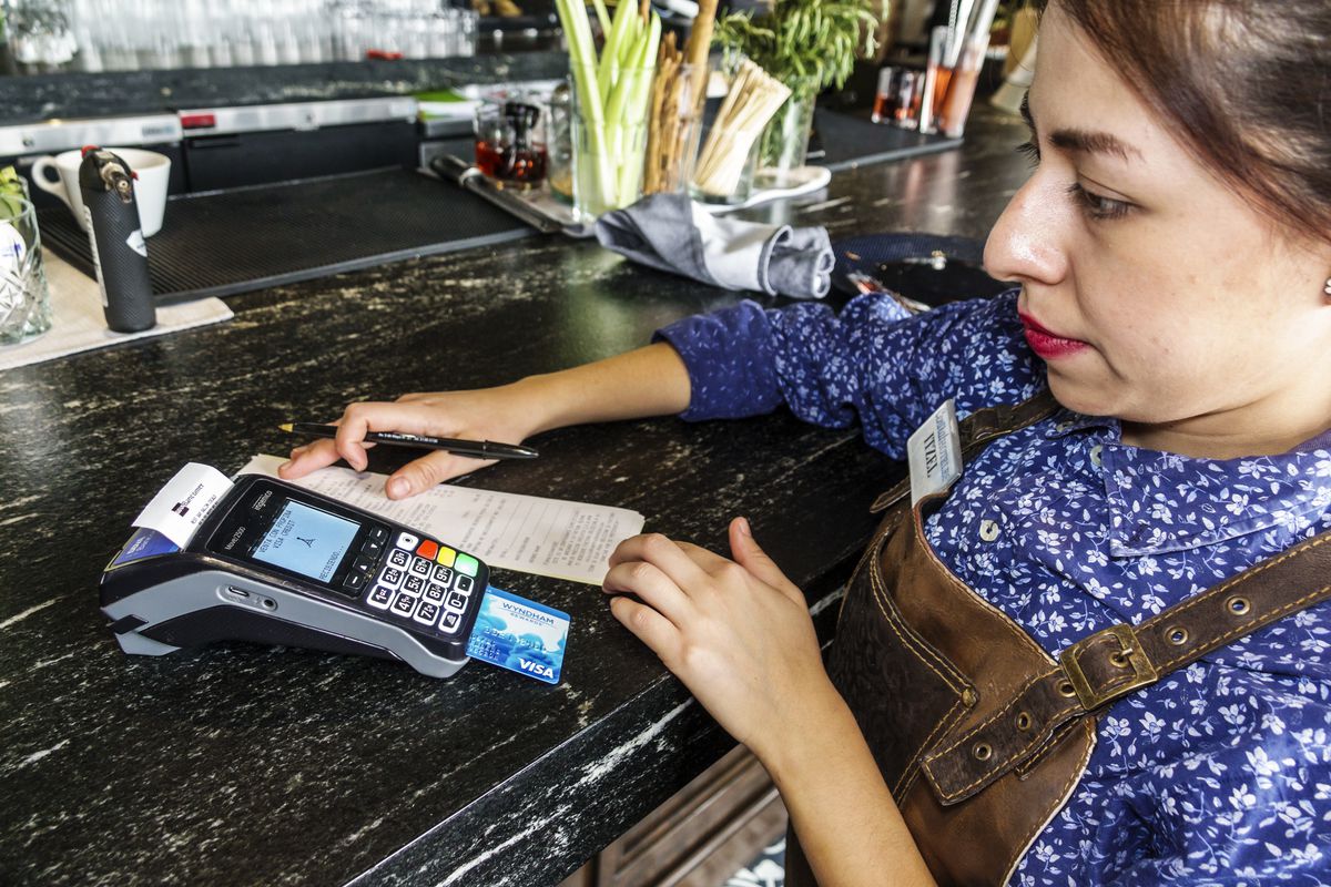 A waitress using a credit card scanner at El Balcon del Zocalo