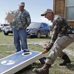 Rich Herbert (left) and his brother-in-law Ty Detmer joke during a game of cornhole on Detmer's T14 Ranch Thursday, Nov. 15, 2018, near Freer, Texas.