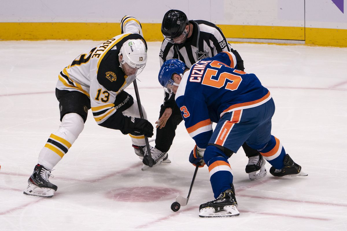 New York Islanders Center Casey Cizikas (53) gains control of the puck at a face-off with Boston Bruins Center Charlie Coyle (13) during the second period of the National Hockey League game between the Boston Bruins and the New York Islanders on February 13, 2021, at the Nassau Veterans Coliseum in Uniondale, NY.