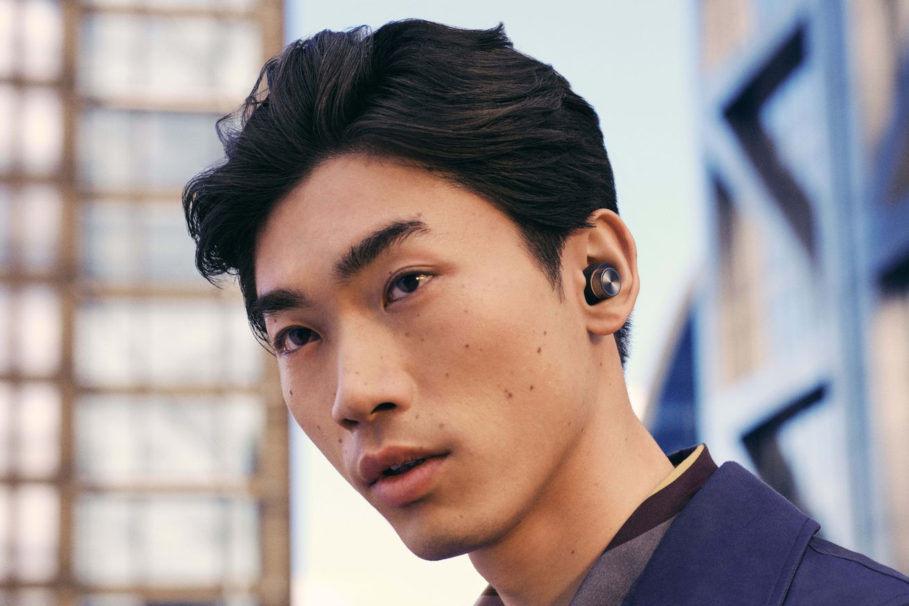 Model wearing the B&amp;W PI7 S2 earbuds.
