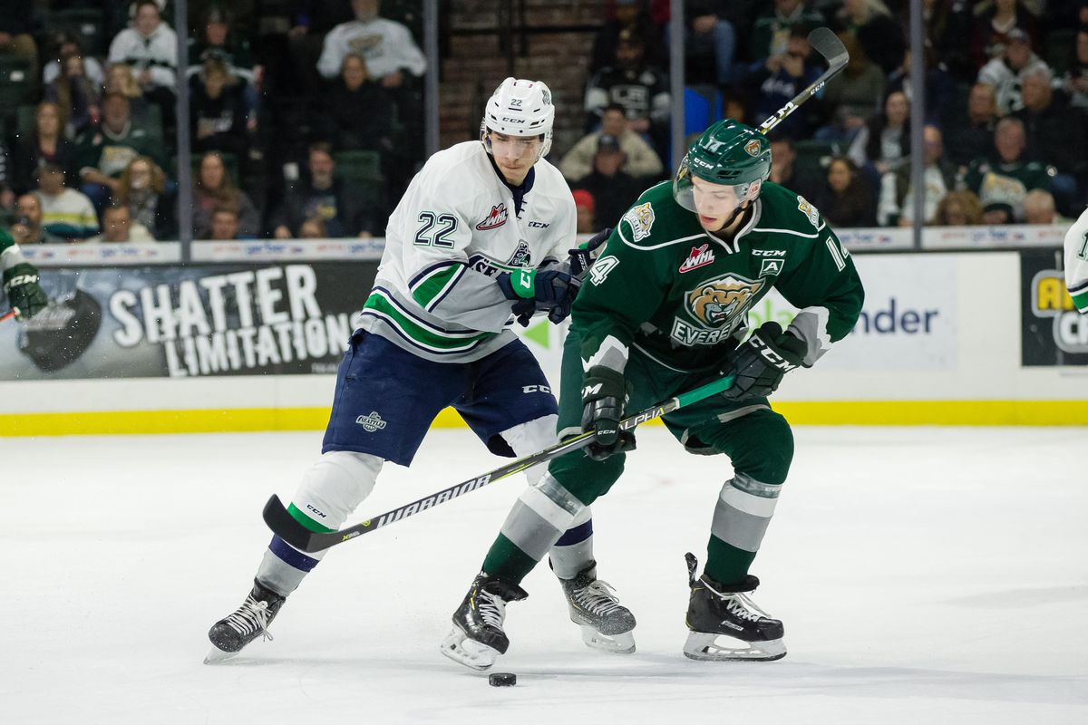 Silvertips forward Riley Sutter tries to control the puck while Thunderbirds forward Dillon Hamaliuk pushes him during a game between the Seattle Thunderbirds and the Everett Silvertips on December 15, 2018 at Angel of the Winds Arena in Everett, WA.