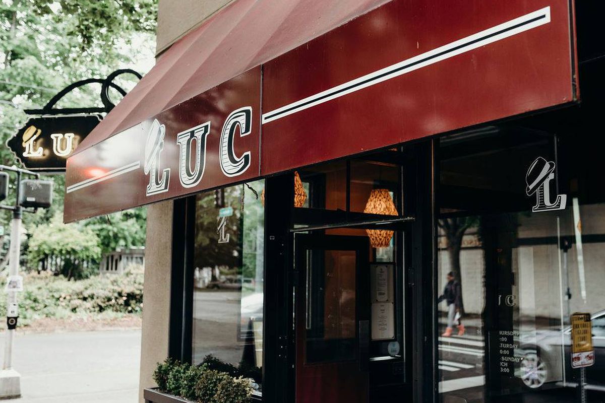 The maroon awning at Luc Bistro in Madison Valley, with the restaurant’s name in all caps and white bordering