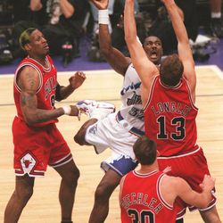 Karl Malone shoots between Luc Longley and Dennis Rodman during Game 6 of the NBA Finals at the Delta Center, June 14, 1998.
