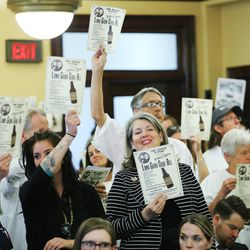 Attendees hold signs as legislators meet during the commission for the stewardship of public lands at the Capitol in Salt Lake City Wednesday, April 20, 2016.