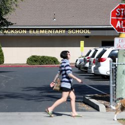A woman and her dog walk past Jackson Elementary School in Salt Lake City on Wednesday, Sept. 27, 2017. The Salt Lake Board of Education will discuss changing the name of elementary school on Tuesday, Feb. 6, 2017. The school was named for Andrew Jackson.