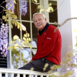 FILE--This 2004 file photo shows former Masters champion Arnold Palmer as he sits on clubhouse railing at the Augusta National Golf Club in Augusta, Ga. Palmer, who made golf popular for the masses with his hard-charging style, incomparable charisma and a personal touch that made him known throughout the golf world as "The King," died Sunday, Sept. 25, 2016, in Pittsburgh. He was 87.  