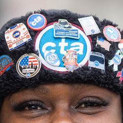 A bus operator, who prefers not to be named, wears a hat with multiple Chicago Transit Authority pins on it as she joins Chicago Transit Authority bus operators, Amalgamated Transit Union 241 members and their allies during a march to Millennium Park in the Loop, Saturday morning, Dec. 11, 2021 to demand the city to protect transit workers. This is in response to what they say is an increased number of assaults against bus operators in the city. | Pat Nabong/Sun-Times