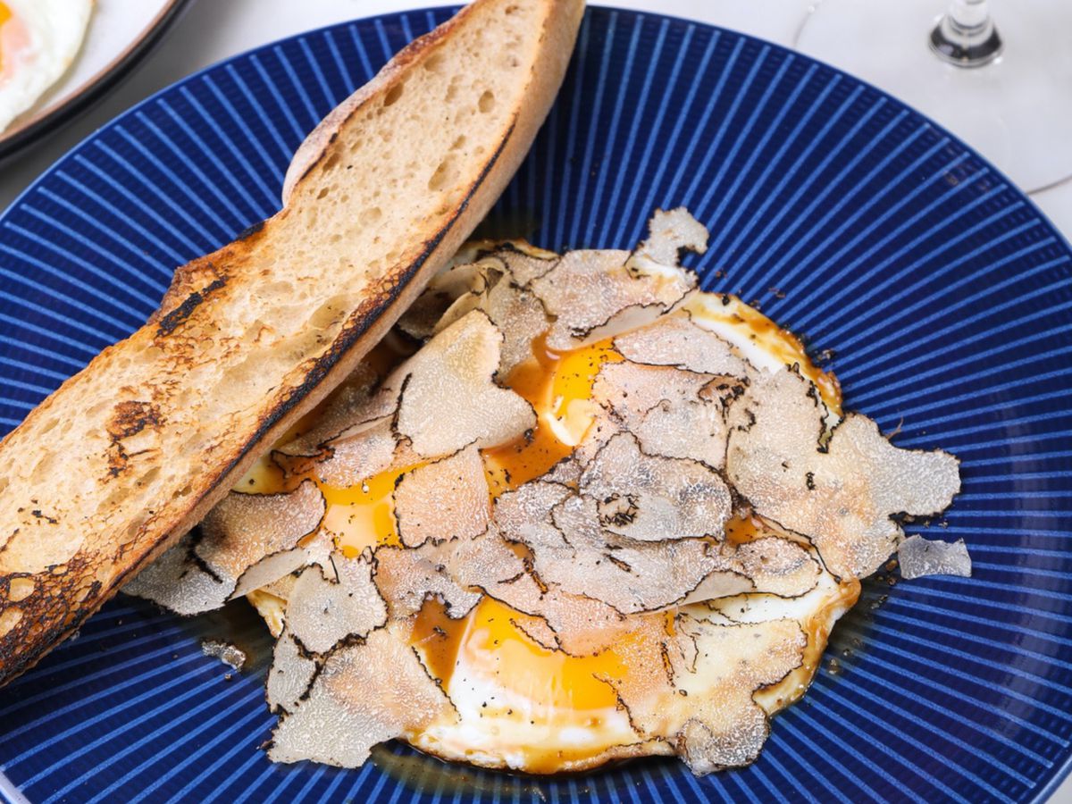 A blue plate with eggs and a side of bread
