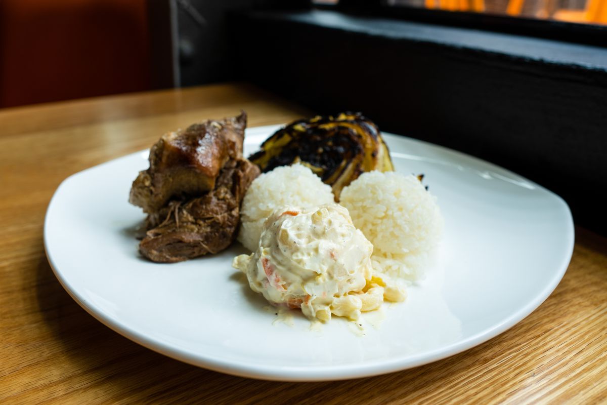 A Kalua pork plate lunch with a side of a side of creamy macaroni salad, a seared wedge of cabbage, and two balls of sticky white rice.