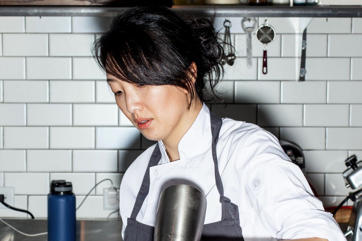 An Asian woman chef in a kitchen.