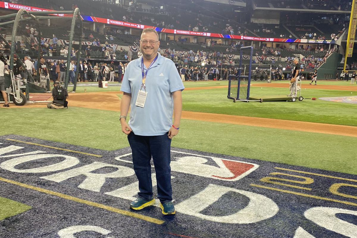 Baseball writer poses on the field during World Series.
