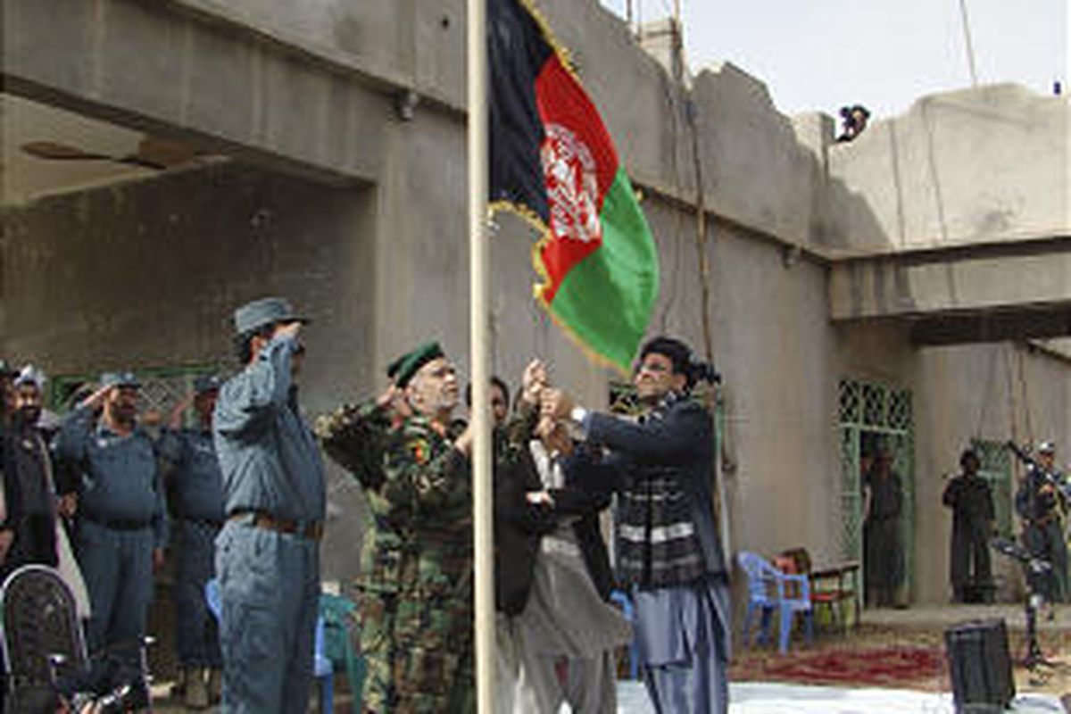 Helmand's governor, Gulab Mangal, right, raises the Afghan national flag Thursday in Marjah.