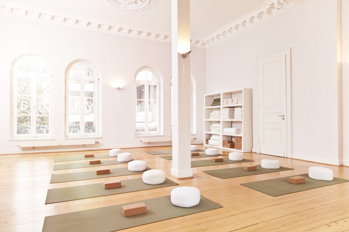 A spacious and empty yoga studio with mats laid out.