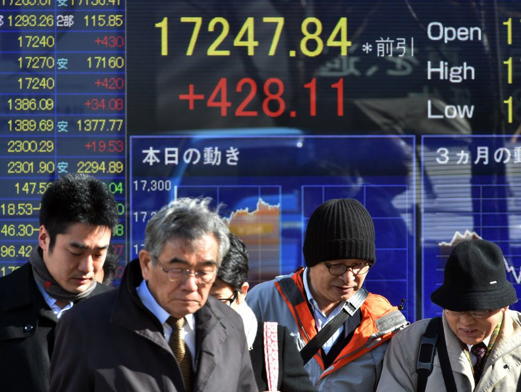 <small><strong>Pedestrians pass before a share prices board in Tokyo on December 18, 2014. Japan’s share prices rose 428.11 points to close at 17,247.84 points at the morning session of the Tokyo Stock exchange, boosted by a rally on Wall Street and a wea