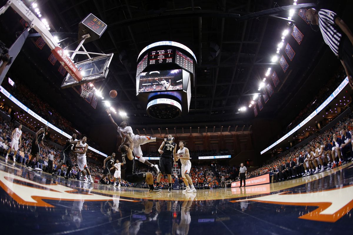 Virginia Cavaliers guard Justin Anderson (1) dribbles the ball as Wake Forest Demon Deacons guard Codi Miller-McIntyre (0) and Demon Deacons forward Devin Thomas (2) defend in the second half at John Paul Jones Arena. The Cavaliers won 74-51.