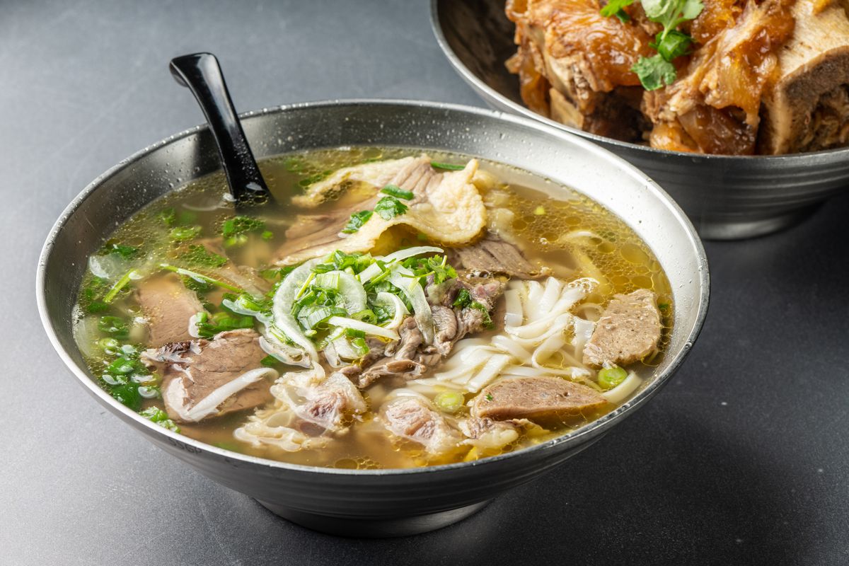 A metal bowl filled with Vietnamese beef noodle soup at Phoholic.