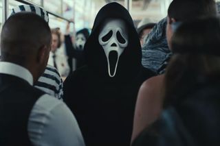 Человек в маске -призраке стоит на многолюдной машине метро Нью -Йорка в неподвижном от Scream VI