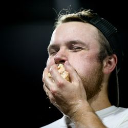 Darrien Thomas, of Ontario, Canada, stuffs himself during a Nathan's Famous qualifier hot dog-eating contest at Smith's Ballpark in Salt Lake City on Tuesday, July 23, 2019. The top male and female finishers in the event qualified for a seat at the 2020 Nathan’s Famous Fourth of July International Hot Dog Eating Contest in Coney Island, New York.