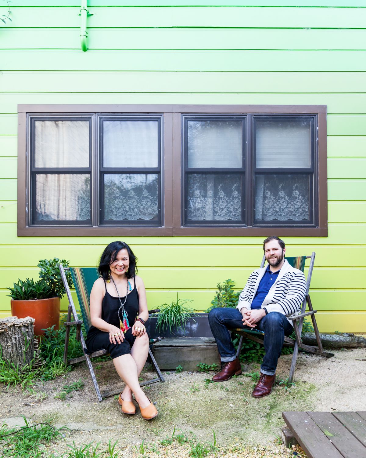 Chien and her boyfriend, Gary L. Baker, stand against the rear exterior wall of the house that she had painted in an ombre pattern.