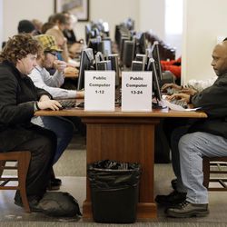 In this Feb. 19, 2015 photo, Larry Lawrence, left, who slept on the street the night before, works at a computer at the Nashville Public Library in Nashville, Tenn. As cuts to social services and mental health programs continue to drive the homeless and disadvantaged to use libraries as day shelters, some libraries are beginning to view services for that population as an important part of their mission. 